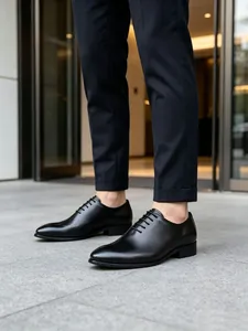 Detalle de los clásicos zapatos Oxford de cuero negro usados con pantalones de vestir