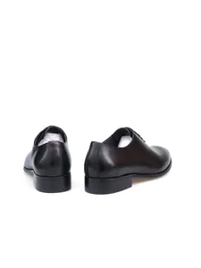Detalle de vista trasera de zapatos Derby de hombre en cuero auténtico color negro