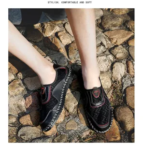 Gros plan de mocassins en maille noire respirante pour hommes sur sol pavé