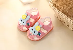 Detail view of pink baby girl sandals with cute rabbit and flower pattern