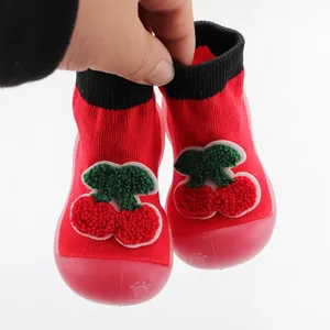 Detail of red baby sock shoes with cute 3D cherry applique and non-slip soft rubber soles.