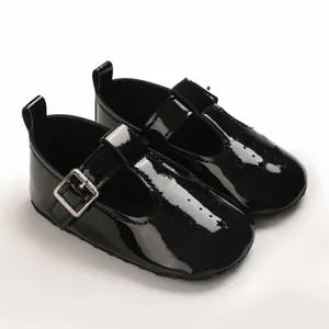 Nahaufnahme von schwarzen Lackleder-Babyschuhen mit dekorativen Sternenausschnitten.