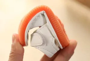 Flexible soft-bottom baby sandal being bent to show durability and comfort for toddlers