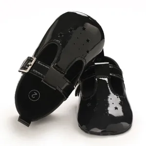 Nahaufnahme von schwarzen Lacklederschuhen für Babys mit Sternenausschnitten