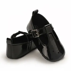 Detail von schwarzen Lackleder-Babyschuhen mit Sternen und Schnalle