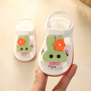 Cute white baby sandals featuring green rabbit and orange flower design with soft soles