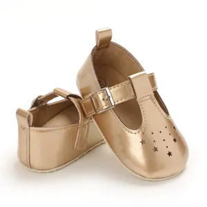 Detaillierte Nahaufnahme goldener Babyschuhe mit Sternenmuster und eleganter Schnalle