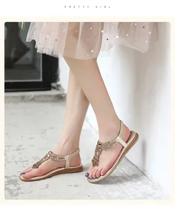 Close-up view of Bohemian T-strap sandals with rhinestone flowers on model feet