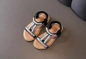 Detail of elegant black girls' sandals decorated with white pearls and sparkling rhinestones