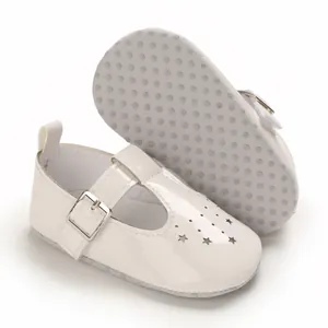 Weiße Babyschuhe mit Sternenausschnitten und rutschfesten Noppensohlen im Detail.