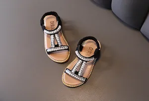 Elegant black girls' Roman sandals featuring pearl and rhinestone T-strap details for summer