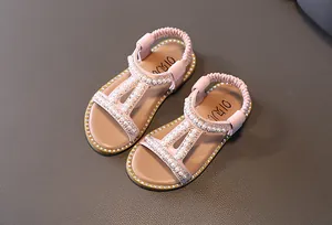 Close-up of pink girls' sandals with elegant pearl and rhinestone embellishments.