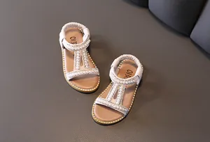 Detailed view of girls' Roman sandals featuring pearls and shiny rhinestone accents.
