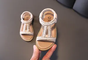 Elegant beige girl's sandals featuring decorative pearl and rhinestone princess straps