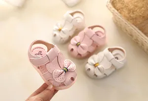 Closed-toe baby girl sandals with bow detail and soft non-slip soles in pink and beige