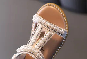 Detailed view of girls' Roman sandals with elegant pearls and sparkling rhinestones