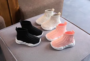 Scarpe da ginnastica in maglia per bambini in vari colori su sfondo di stoffa grigia