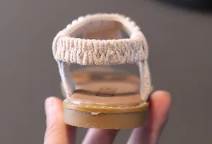 Detail view of girl's sandal heel strap with elegant pearl and rhinestone embellishments.