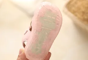 Close-up detail of the pink non-slip soft rubber sole of a toddler girl sandal shoe.