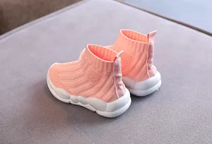 Dettaglio delle sneakers a calzino in maglia rosa per bambini con suola bianca.