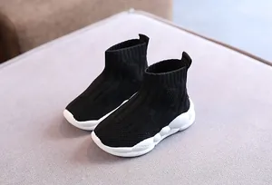 Vista dettagliata delle sneakers a calzino alte in maglia nera per bambini con suola bianca