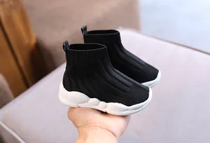 Dettaglio di scarpe da ginnastica in maglia nera traspirante per bambini con suola bianca