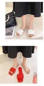 Macro view of stylish woven strap slides for women in elegant white and red colors.