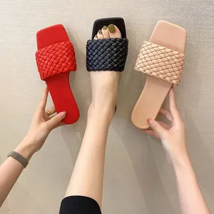 Close-up detail of women's woven strap flat sandals in red black and nude colors