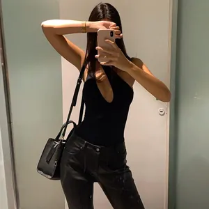Detail shot showing the sexy slim fit of this black cutout bodysuit for women
