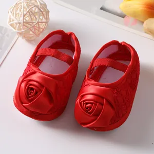 Detailweergave van rode baby prinsessenschoenen met grote satijnen roos en kanttextuur