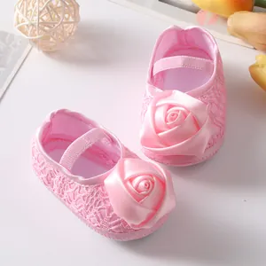 Detail van roze baby prinsessenschoenen met grote satijnen roos en delicaat kant