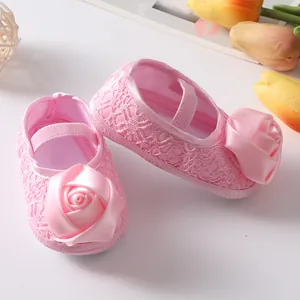 Detailopname van roze kanten babyschoentjes met elegante roosdecoratie