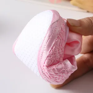 Detail van zachte roze kanten babyschoen die flexibiliteit en meshstof laat zien