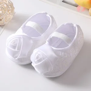Detailweergave van witte baby prinsessenschoenen met decoratieve satijnen roosjes