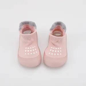 Vista frontal detallada de zapatos tipo calcetín para bebé en rosa con suela blanda
