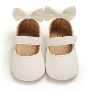 Detaillierte Draufsicht cremefarbener Baby-Lauflernschuhe mit dekorativen großen Schleifen