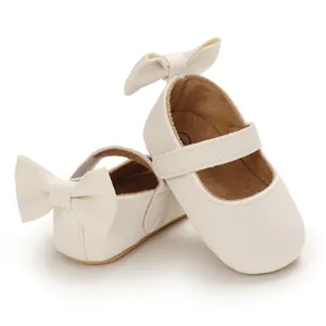 Detailansicht cremefarbene Baby-Mary Janes mit großer Rückenschleife und Lederstruktur.
