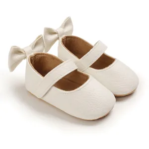 Nahaufnahme weißer Lauflernschuhe für Babys mit weicher Sohle und Fersenschleife