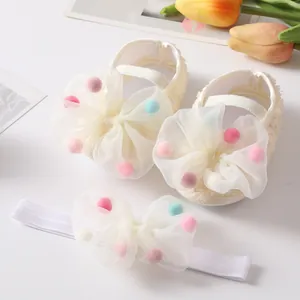 Close-up of baby princess shoes and headband set with colorful pom-pom mesh bow details
