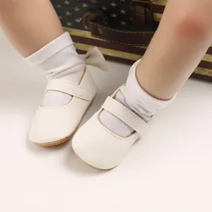 Nahaufnahme von cremefarbenen Baby-Lauflernschuhen mit weicher Sohle und Klettverschluss