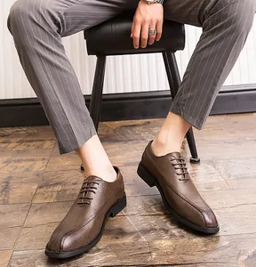 Close-up of brown men's business casual leather shoes worn with striped trousers.