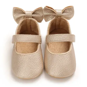 Detailansicht goldene Babyschuhe mit weicher Sohle und Schleife für Mädchen