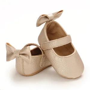 Detailansicht von weichen metallic champagnerfarbenen Baby-Mary-Janes mit Schleife.