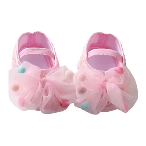 Cute pink infant princess shoes featuring large tulle bows and colorful mini pom-poms