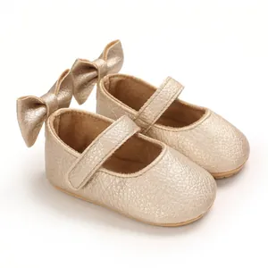 Nahaufnahme champagner goldene Baby-Mary-Janes mit großer Schleife und Kunstledertextur
