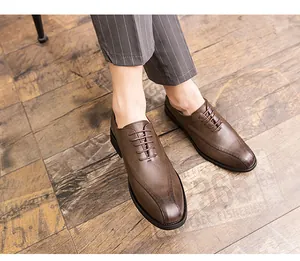 Detailed top-down view of brown leather formal shoes worn with striped trousers