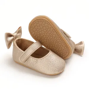 Detailansicht der goldenen Baby-Prinzessin-Schuhe mit Schleife und weicher Sohle