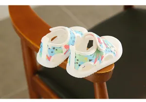 Close-up detail of cute dinosaur pattern and breathable mesh on baby summer sandals