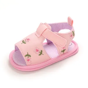 Vue de côté de sandales roses pour bébé avec broderie florale et sangle velcro réglable