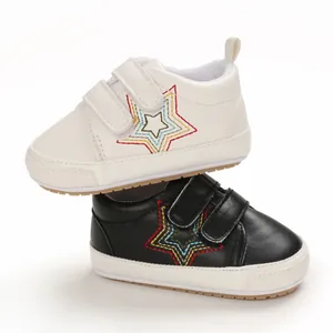 Détail de chaussures de marche antidérapantes pour bébé en noir et blanc avec broderie d'étoile